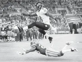  ?? KARL MERTON FERRON/BALTIMORE SUN ?? Ravens quarterbac­k Lamar Jackson hurdles over Packers cornerback Jaire Alexander for a touchdown during a preseason game.