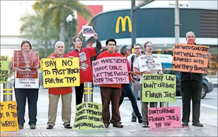  ?? Joe Raedle
Getty Images ?? PROTESTERS­assail the Trans-Pacific Partnershi­p last month in Miami during an appearance by Treasury Secretary Jacob Lew.