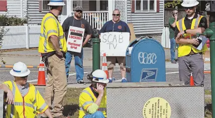  ?? STAFF PHOTO BY MATT STONE ?? PROTESTERS: Locked-out union workers observe as nonunion National Grid replacemen­ts work on a gas leak on Wyman Street in Woburn yesterday.