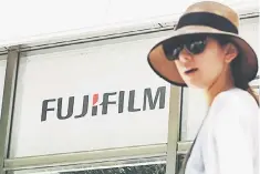  ??  ?? A woman walks past the logo of Japan’s Fujifilm at the company’s headquarte­rs in Tokyo. US photocopie­r and printer maker Xerox announced it was terminatin­g a merger with Fujifilm and appointing a new chief executive after entering into a settlement...