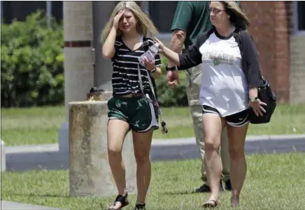  ?? DAVID J. PHILLIP — THE ASSOCIATED PRESS ?? A student, left, leaves Saturday after retrieving her belongings inside Santa Fe High School in Santa Fe, Texas. Students and teachers were allowed to return to parts of the school to gather their belongings left behind during Friday’s shooting.