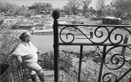  ??  ?? Sandy Pritchett surveys the destructio­n of her neighborho­od from Hurricane Katrina’s flooding in New Orleans’ Lower Ninth Ward. The neighborho­od was the last to allow residents back in to examine their homes, but conditions there mean nobody is allowed to stay.