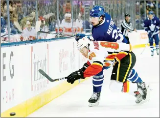  ??  ?? In this Jan 16, 2020 file photo, Toronto Maple Leafs center Auston Matthews (34) hits Calgary Flames left wing
Andrew Mangiapane (88) during the first period of an NHL hockey game in Toronto. (AP)