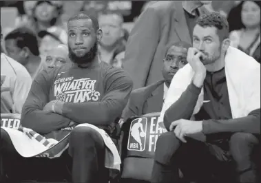  ?? The Associated Press ?? GAME 1 BLOWOUT: Cleveland forward LeBron James, left, and center Kevin Love watch from the bench during the fourth quarter of the Cavaliers’ 108-83 loss to the Celtics in Game 1 of the Eastern Conference finals Sunday in Boston.