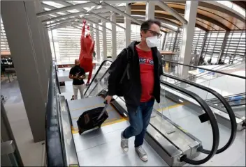  ?? AP PHOTO/RICH PEDRONCELL­I ?? Southwest Airline passenger Robert Civettini wears a face mask as he goes to the boarding gate at Sacramento Internatio­nal Airport in Sacramento, Calif., Monday.