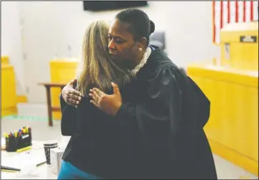  ?? The Associated Press ?? JUDGE’S HUG: State District Judge Tammy Kemp gives former Dallas Police Officer Amber Guyger a hug before Guyger leaves for jail, Wednesday, in Dallas. Guyger, who said she mistook neighbor Botham Jean’s apartment for her own and fatally shot him in his living room, was sentenced to a decade in prison.