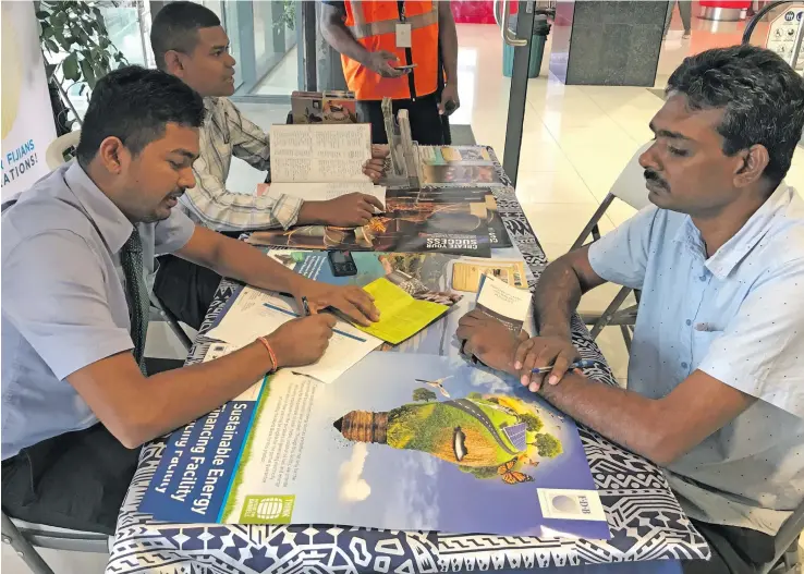  ?? Photo: Yogesh Chandra ?? Satish Kumar (right) being served by staff of Fiji Developmen­t Bank at TappooCity Lautoka on September 19, 2018.