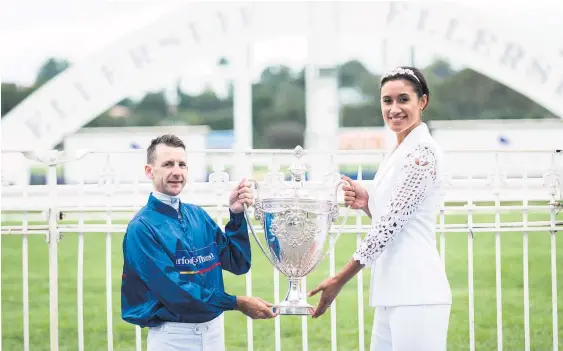 ??  ?? Maria Tutaia and jockey Leith Innes hold the Auckland Cup, which will be won in the feature race today.
