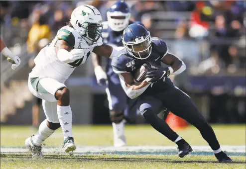  ?? Michael Dwyer / Associated Press ?? UConn running back Art Thompkins, right, carries against South Florida linebacker Demaurez Bellamy (41) during the first half in East Hartford on Saturday.