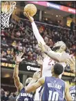  ??  ?? Cleveland Cavaliers’ LeBron James (center), drives to the basket against Memphis Grizzlies’ Tony Allen (left), and Troy Williams in the first half of an NBA basketball game on Dec 13, in
Cleveland. (AP)