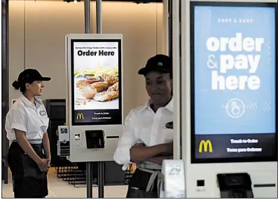  ?? AP/NAM Y. HUH ?? Employees stand near new self-order kiosks last week in the McDonald’s Corp. flagship restaurant in Chicago. The burger chain and its franchisee­s are modernizin­g their restaurant­s nationwide.