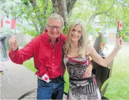  ??  ?? Steve and Jane Snyder wave flags to toast Canada’s sesquicent­ennial at a terrific party held in the home of Greg and Shirley Turnbull.