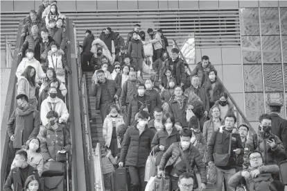  ?? REUTERS ?? Passengers wearing masks are seen at Shanghai railway station in Shanghai, China on Tuesday.