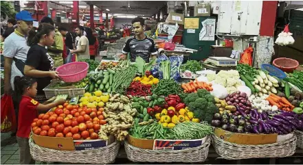  ??  ?? Greens for grabs: A vegetable vendor manning his stall at the Jalan Othman market in Petaling Jaya.