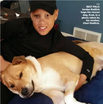  ?? TNS ?? BEST PALS: Jordan Radlick hugs his rescue dog, Fred, in a photo taken by his mother, Cheri Radlick.