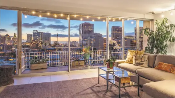  ??  ?? This great room in Oakland features floor-to-ceiling glass windows that step out to a terrace with city views.