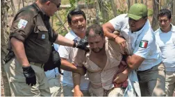  ??  ?? Mexican immigratio­n agents detain a Central American migrant on the highway to Pijijiapan, Mexico, last month.