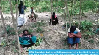  ?? — AFP ?? UKHIA, Bangladesh: Newly arrived Rohingya refugees rest by the side of the road on their way to the Thangkhali refugee camp at Balukhali in the Bangladesh­i district of Ukhia yesterday.
