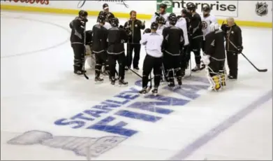  ?? AP Photo ?? Bruins players gather on the ice during an optional workout Tuesday in Boston.