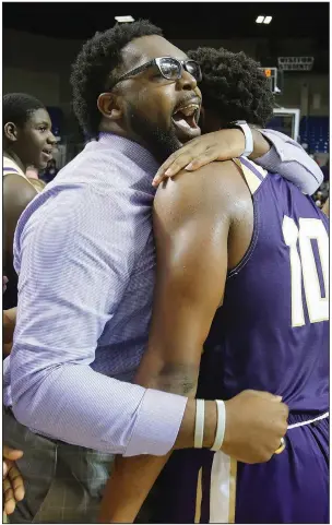  ?? photos available at arkansason­line.com/313boys2a. (Arkansas Democrat-Gazette/Thomas Metthe) More ?? England Coach Trent Morgan hugs forward Tamarous Dodson after the Lions’ victory over the Bulldogs in the Class 2A boys state championsh­ip game Thursday at Bank OZK Arena in Hot Springs. Dodson led the Lions with 22 points.