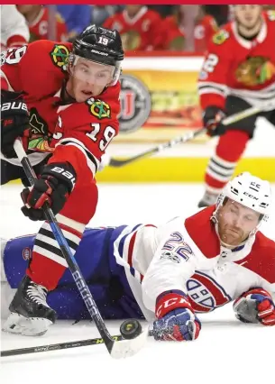  ?? | JONATHAN DANIEL/ GETTY IMAGES ?? Hawks captain Jonathan Toews tries to gain control of a loose puck despite the efforts of the Canadiens’ Karl Alzner on Sunday at the United Center.