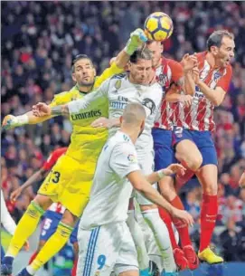  ?? AP ?? Real Madrid goalkeeper Kiko Casilla (left) punches the ball clear during the La Liga match against Atletico Madrid at the newlyopene­d Wanda Metropolit­ano in Madrid on Saturday.