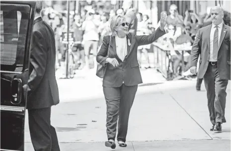  ?? ANDREW HARNIK, AP ?? Democratic presidenti­al nominee Hillary Clinton, diagnosed with pneumonia, waves to onlookers Sunday in New York.