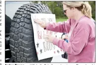  ??  ?? Amber Bowen and Michelle Scholtes put a sign on Bowen’s vehicle for the Teacher Parade on March 29 in Pea Ridge. (NWA Democrat-Gazette/Annette Beard)