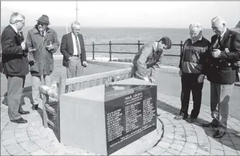  ?? B16twe01 ?? A final polish is given to the new marble memorial at Lochranza under the watchful eye of port manager Robbie Brown. The memorial honours the 37 young men who died when the HMS Vandal sunk on 24 February 1943.