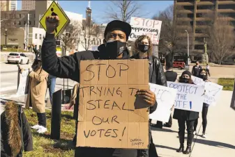  ?? Megan Varner / Getty Images ?? Demonstrat­ors outside the Georgia Capitol building in Atlanta protest against a bill that restricts ballot drop boxes, requires ID for absentee voting and limits weekend early voting.