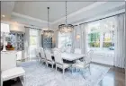  ?? ?? The dining room is anchored by two sparkling chandelier­s that hang from a tray ceiling.