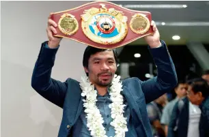  ?? — AFP ?? Philippine boxing icon Manny Pacquiao holding his welterweig­ht title belt in Manila after defeating Mexican boxer Jessie Vargas in his last fight.