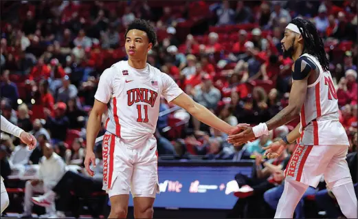  ?? STEVE MARCUS ?? UNLV guard D.J. Thomas Jr. (11) is congratula­ted by teammate Keylan Boone (20) after making a free throw Feb. 24 against Colorado State at the Thomas & Mack Center.