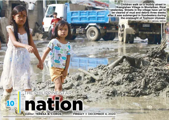  ?? MICHAEL VARCAS ?? Children walk on a muddy street in Kasiglahan Village in Montalban, Rizal yesterday. Streets in the village have yet to be cleared of mud and debris three weeks after it was submerged in floodwater­s during the onslaught of Typhoon Ulysses.