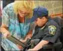  ??  ?? Make-A-Wish recipient Jordan Barahmeh signs his name to become an honorary Oneida City Police officer on Tuesday, Aug. 29, 2017. With him is Oneida City Clerk Sue Pulverenti.