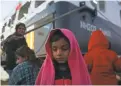  ?? ORESTIS PANAGIOTOU/EPA-EFE ?? Refugees wait for transport after they arrived on the ferry Nissos Samos from Lesbos island at the port of Piraeus, Greece, on Dec. 11.