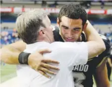  ??  ?? An emotional Sefo Liufau hugs coach Mike MacIntyre after the Alamo Bowl on Thursday night. Cliff Grassmick, Daily Camera