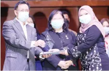  ?? — Photo by Chimon Upon ?? Dr Rundi (left) presents the award to a staff member, as the ministry’s permanent secretary Dato Alice Jawan looks on.