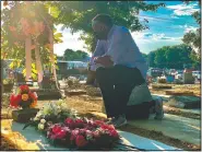  ?? (AP/Kim Chandler) ?? Will Boyd kneels at the grave of a family member who died after contractin­g the coronaviru­s Saturday in Montgomery, Ala. He says his family has lost multiple family members to covid-19.