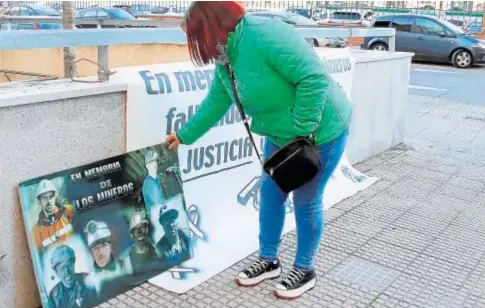  ?? // ICAL ?? Una allegada de las víctimas coloca una imagen de los seis mineros fallecidos durante el juicio celebrado en León
