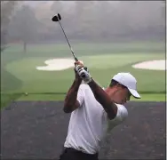  ?? Curtis Compton / TNS ?? Defending champion Tiger Woods tees off in the rain on the par-3 4th hole during his practice round for the Masters at Augusta National Golf Club on Wednesday in Augusta, Ga.