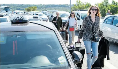  ?? BERTRAND LANGLOIS/AFP/GETTY IMAGES ?? Taxi drivers block the access of the airport of Marignane near southern France on Friday to demonstrat­e against UberPop.