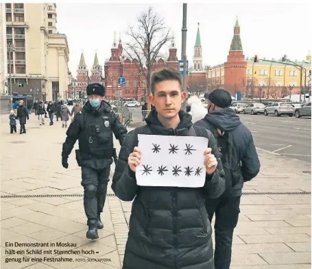  ?? FOTO: SOTA/AP/DPA ?? Ein Demonstran­t in Moskau hält ein Schild mit Sternchen hoch – genug für eine Festnahme.