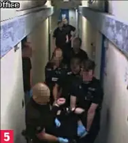  ??  ?? Staff carry him down the corridor with the belt still covering his head