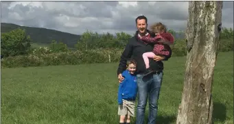  ??  ?? Muiris Walsh with his children Tom and Doireann at the standing stone that inspired his business.