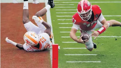  ?? JOHN BAZEMORE/ASSOCIATED PRESS ?? Georgia quarterbac­k Stetson Bennett dives past Tennessee defensive back Jaylen McCollough to score a touchdown in the first half of the Bulldogs’ victory over the Volunteers on Saturday. No. 3 Georgia shook off early struggles to win going away against the No. 14 Volunteers.