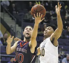  ?? Ben Margot / Associated Press ?? St. Mary’s Jordan Ford lays up a shot past Cal’s Justice Sueing in the second half of the Gaels’ 74-63 victory at Haas Pavilion.