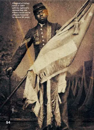  ??  ?? A portrait of Carney taken in 1864 with his regiment’s national flag. His bravery would not be officially honoured for almost 40 years