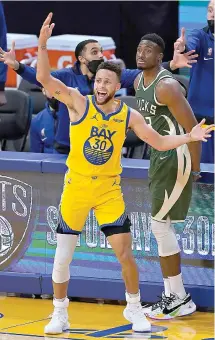  ?? AP Photo/Jeff Chiu ?? ■ Golden State Warriors guard Stephen Curry (30) reacts after being fouled by Milwaukee Bucks forward Thanasis Antetokoun­mpo, rear, during the second half of an NBA game Tuesday in San Francisco.