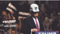  ?? TY WRIGHT/THE NEW YORK TIMES ?? Donald Trump wears a miner’s hard hat at a campaign rally in 2016 in Charleston, W.Va. The Republican Party’s fast journey from debating how to combat climate change to arguing that it does not exist is a story of big political money and a deepening...